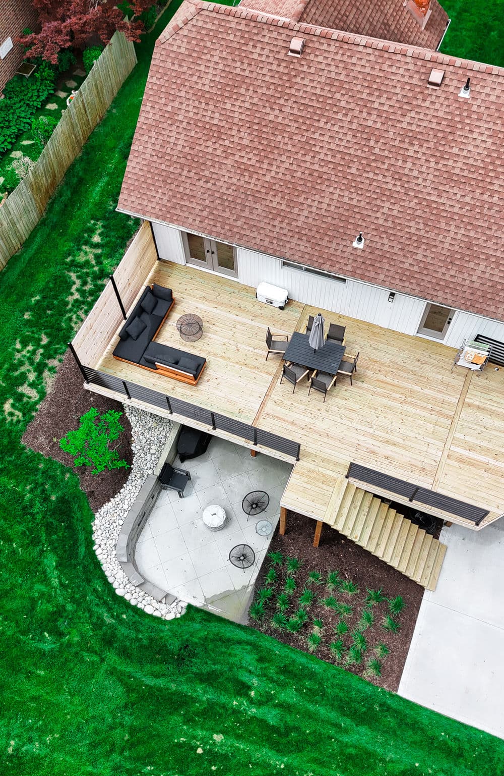 Aerial view of a modern wooden deck with outdoor seating and landscaped garden.